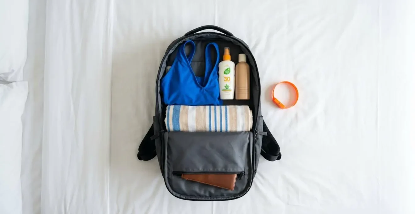 Gepackter Rucksack mit Badesachen, Handtuch und einem Wristband für die Schaumparty.